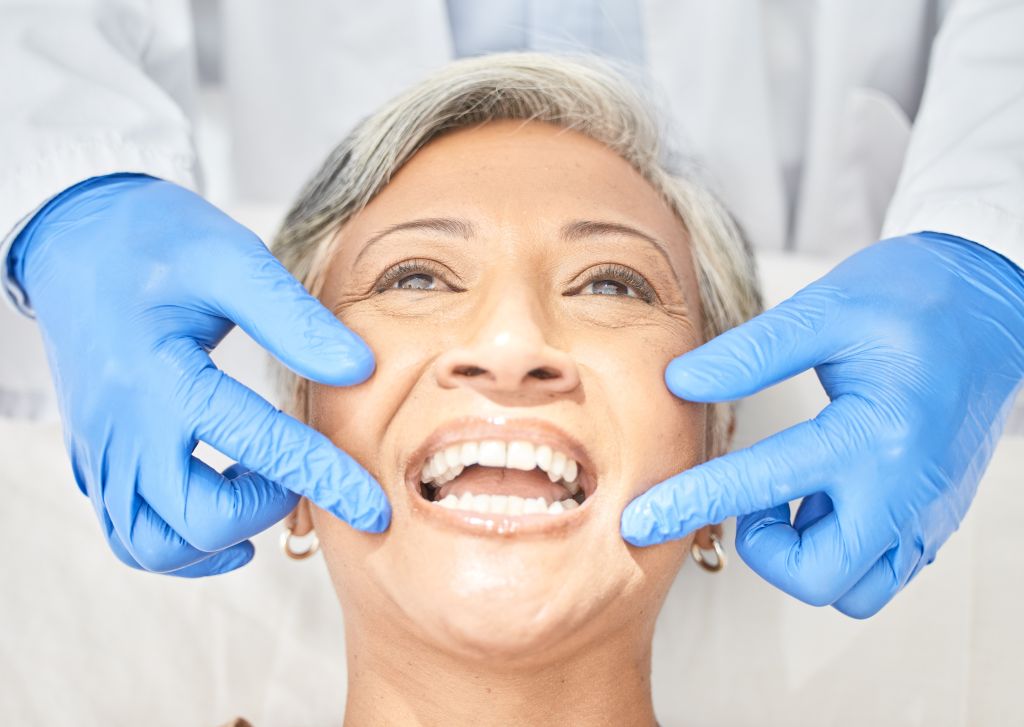 Senior patient smiling during a dental exam in Lemont, IL.