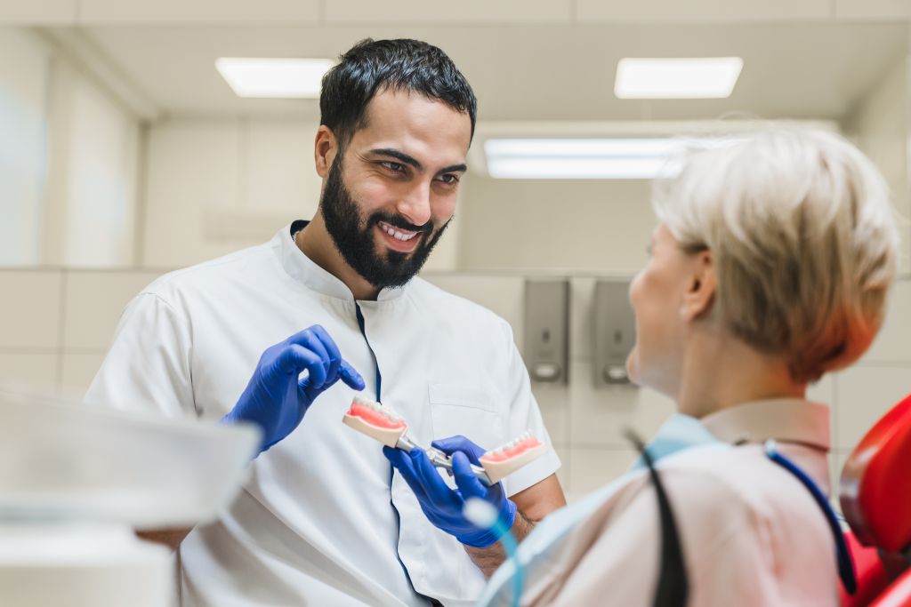 Dentist demonstrating proper brushing technique at a Lemont, IL dental office.